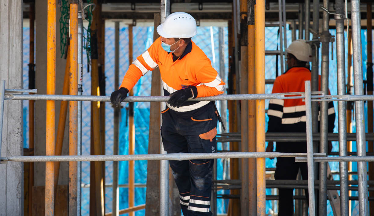 Mataró, BARCELONA, SPAIN; April 14 2020: Construction workers return to work with masks protected against Covid-19  Back to work  Building construction 