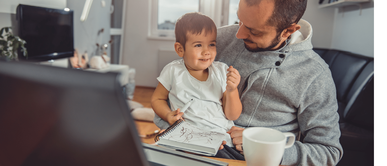 Father playing with his little son at home office