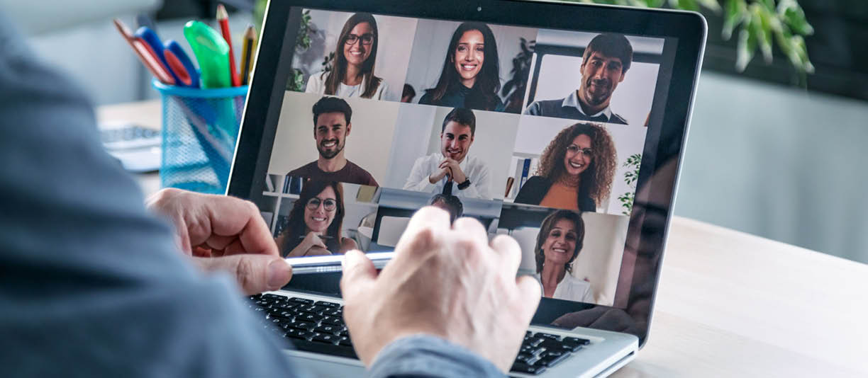 Back view of male employee speaking on video call with diverse colleagues on online briefing with laptop at home 