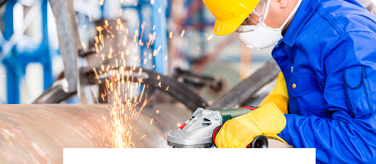 Industrial worker in manufacturing plant grinding to finish a pipeline