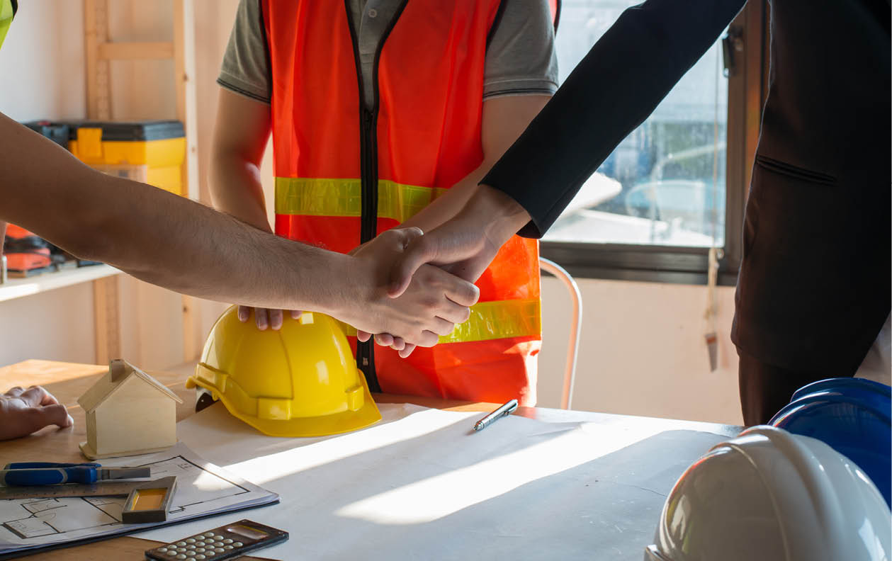 Close up construction worker or engineer shaking hands after finish an agreement or contract 