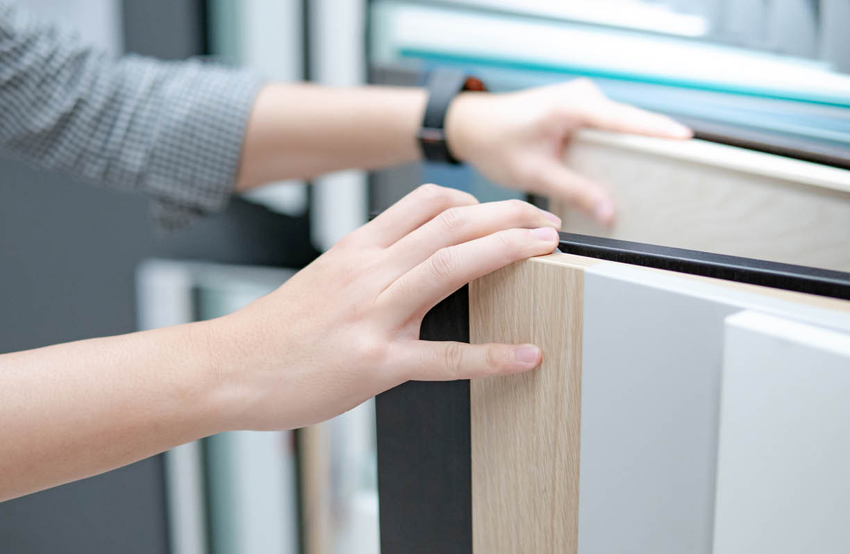 Male hand choosing cabinet panel materials or countertops for built-in furniture design  Shopping furniture and decoration  Home improvement concept